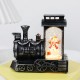 Decoratiune de Craciun tip Locomotiva, Flippy, Glob de Cristal cu Fulgi de Zapada, Model Om de Zapada, Iluminare LED, 11.5 x 12.5 x 6 cm, Carcasa Vintage Bronze, Transparent Decoratiune de Craciun tip Locomotiva, Flippy, Glob de Cristal cu Fulgi de Zapada, Model Om de Zapada, Iluminare LED, 11.5 x 12.5 x 6 cm, Carcasa Vintage Bronze, Transparent